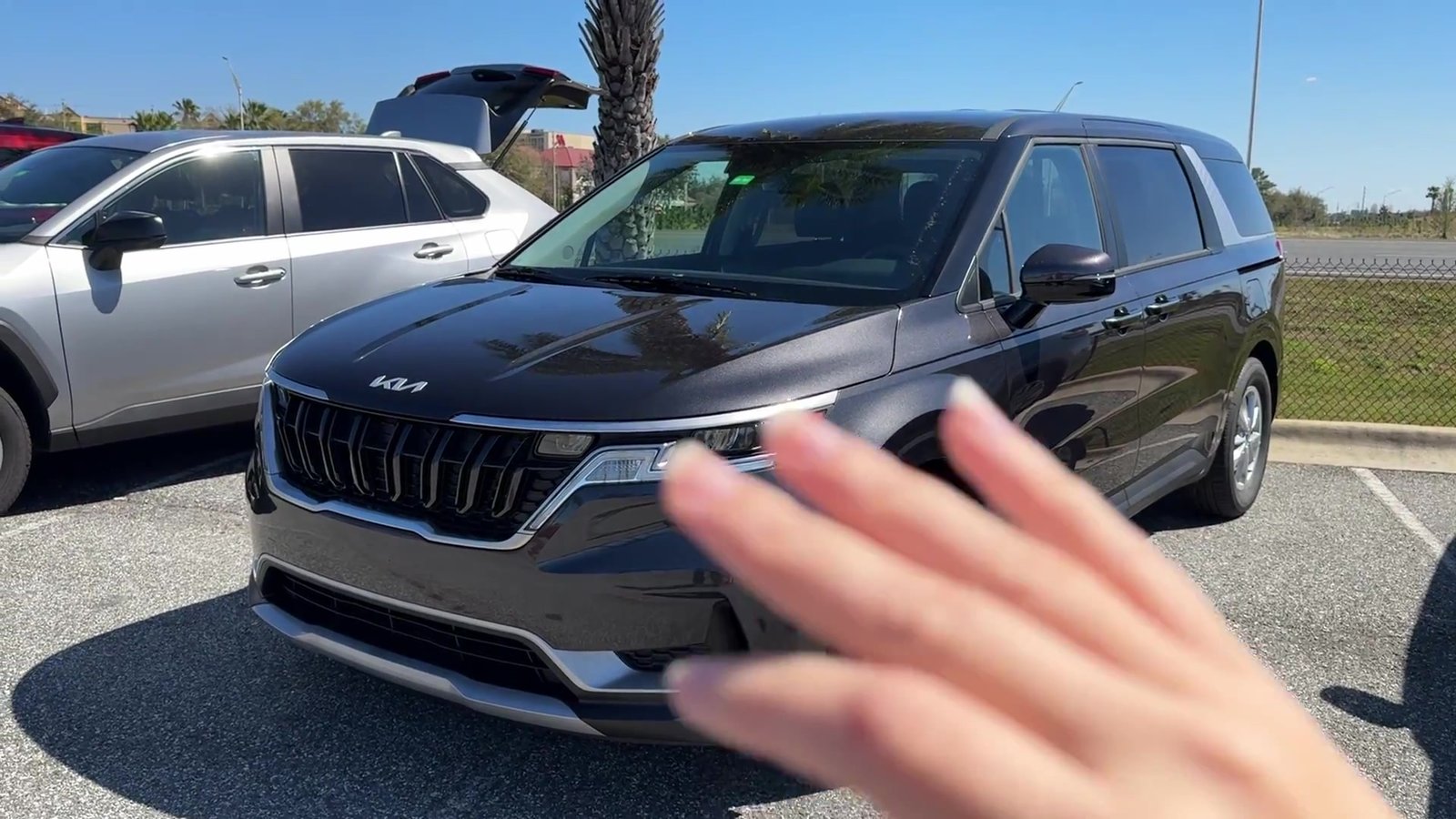 Minivan Kia Carnival preta no pátio da locadora em Orlando
