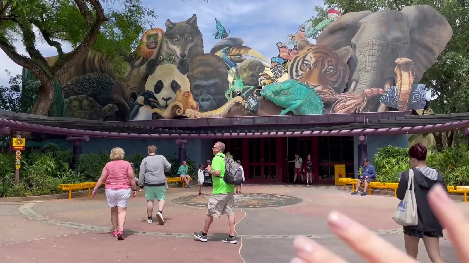 Fachada da Conservation Station com o mural de animais pintados e visitantes entrando