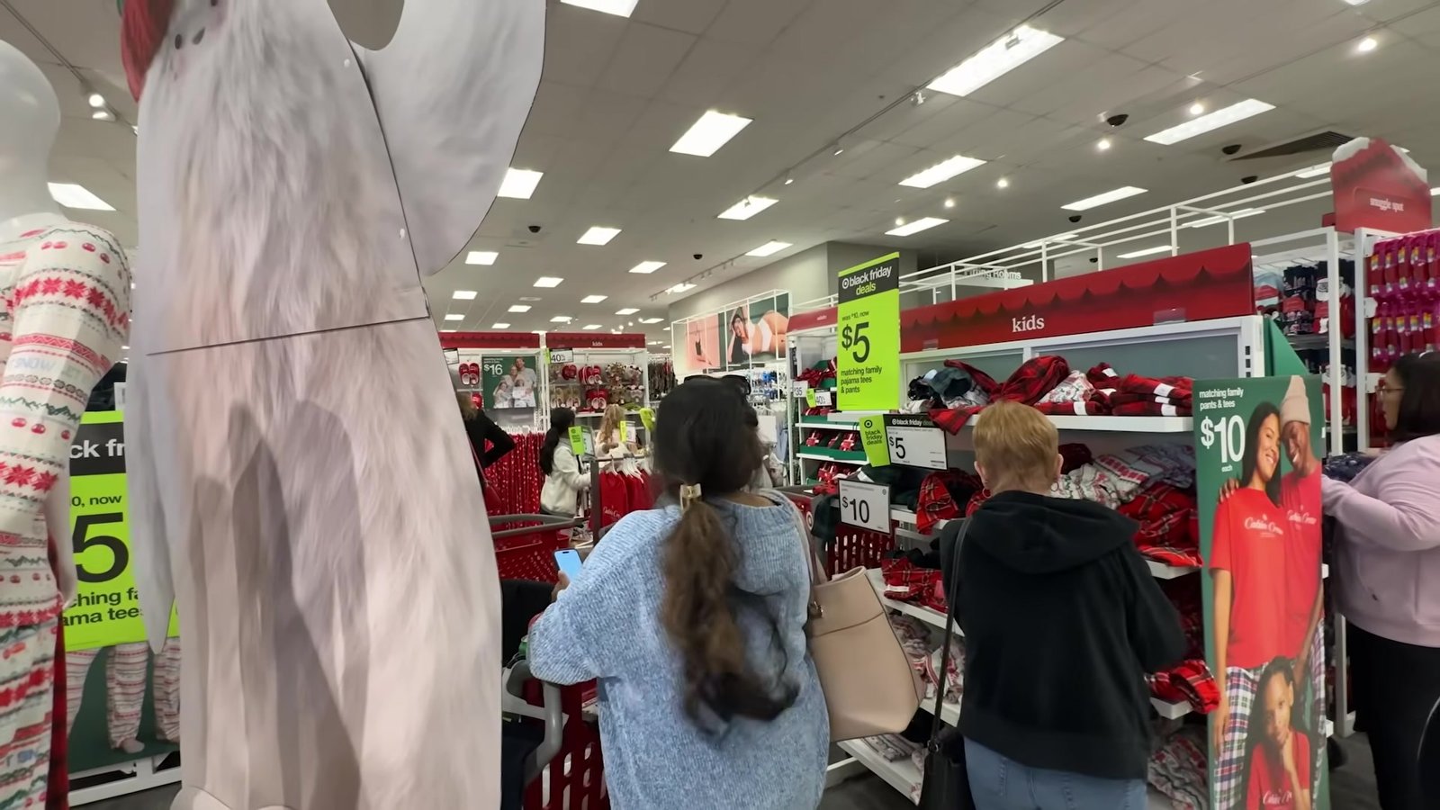 Corredor da Target com pijamas de US$ 5 e US$ 10 e clientes garimpando na Black Friday