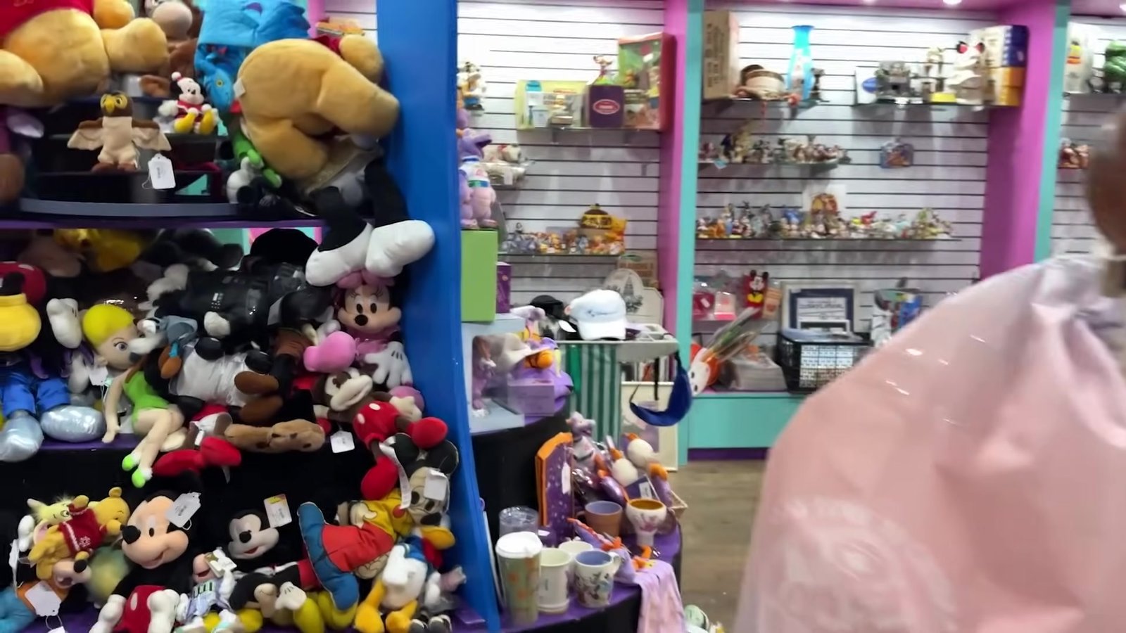 Parede de pelúcias do Mickey e prateleiras de colecionáveis no interior do Recycling the Magic
