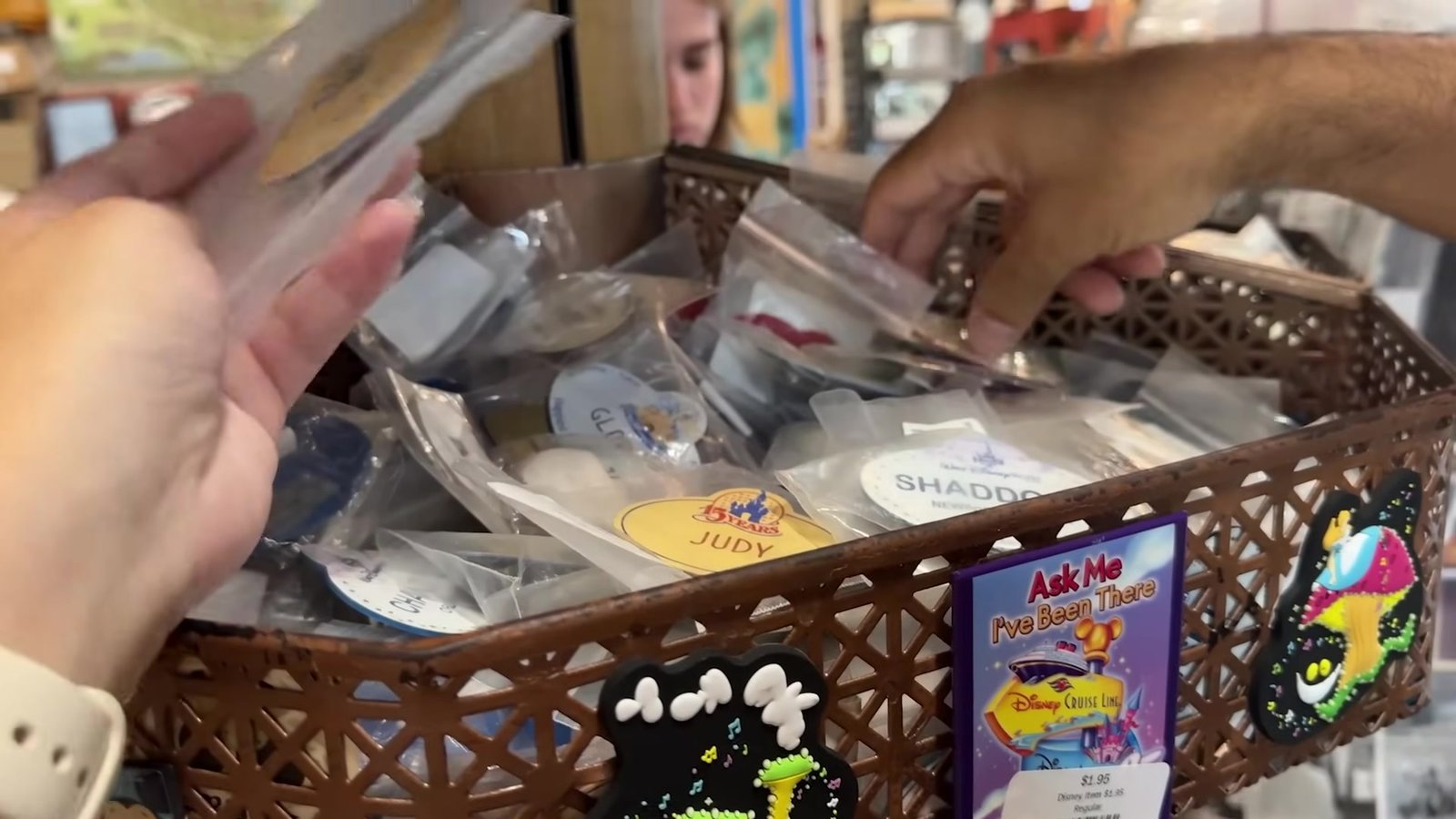 Cesta com crachás de Cast Members da Disney embalados individualmente no Recycling the Magic
