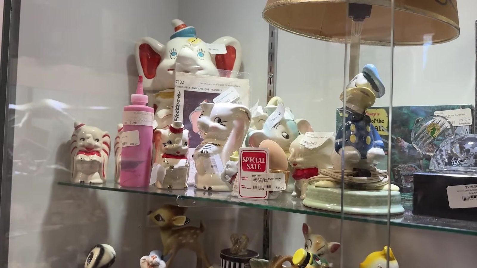 Vitrine de vidro com estatuetas do Dumbo, do Grilo Falante e de outros clássicos no brechó