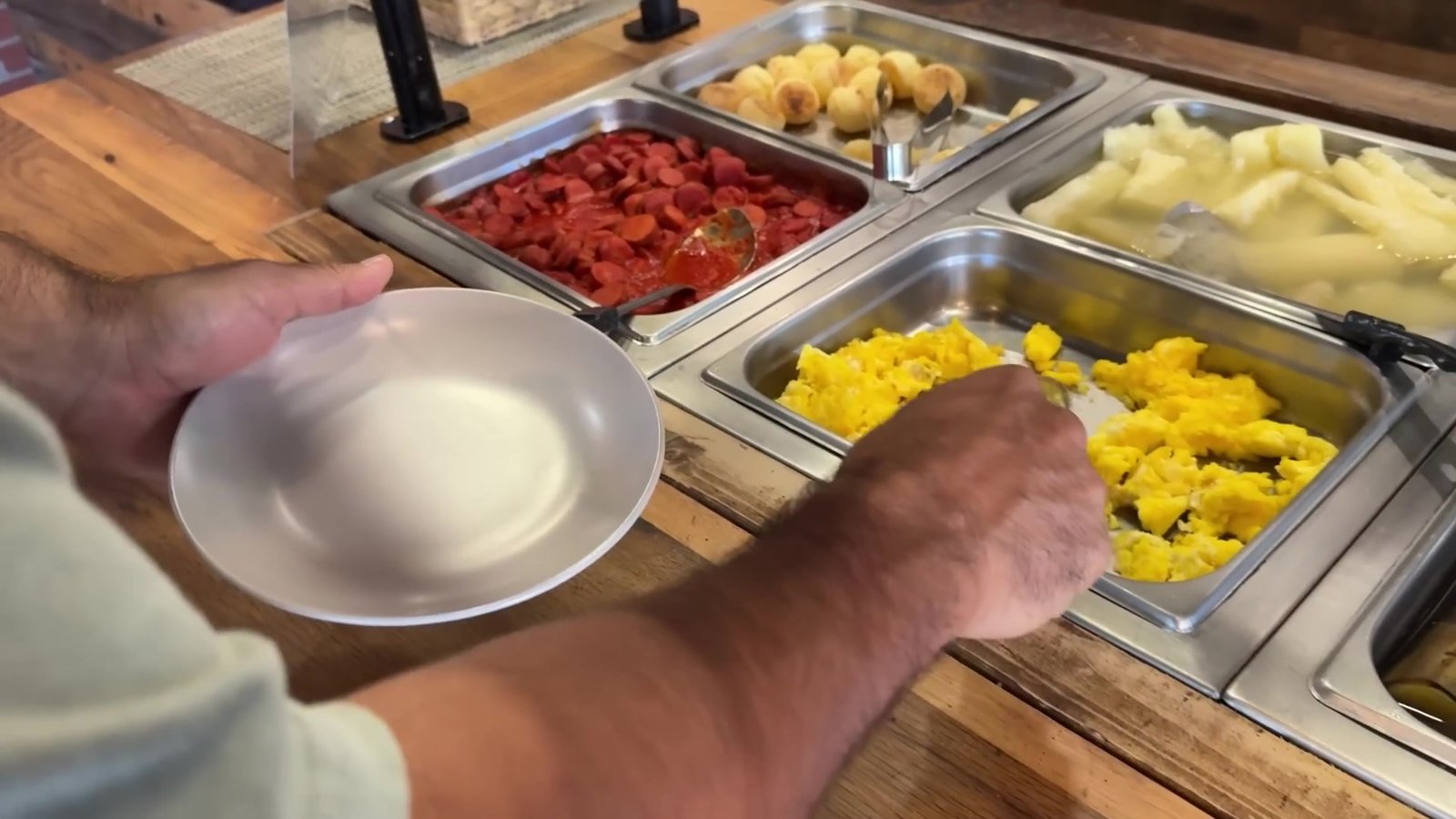 Cubas do buffet quente do Laçador Grill com ovos mexidos, salsicha picada e mandioca