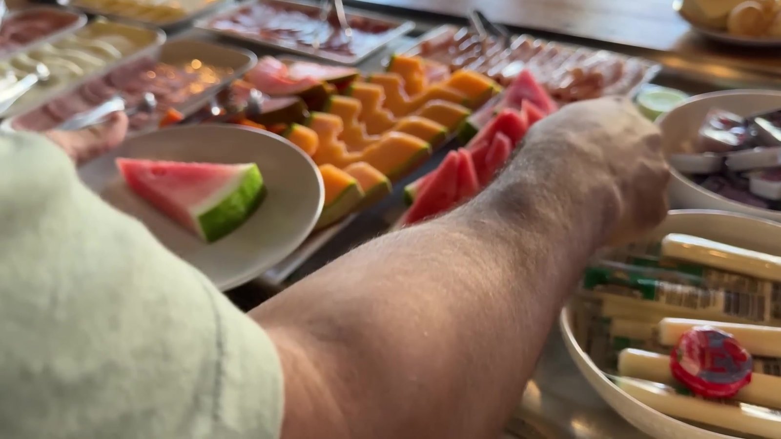 Bandejas de mamão, melancia e melão cortados no buffet de café da manhã