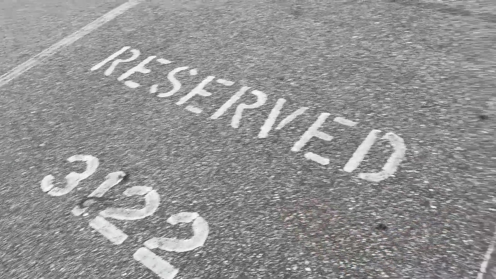 Vaga de estacionamento pintada com "Reserved" e o número da casa no Magic Village
