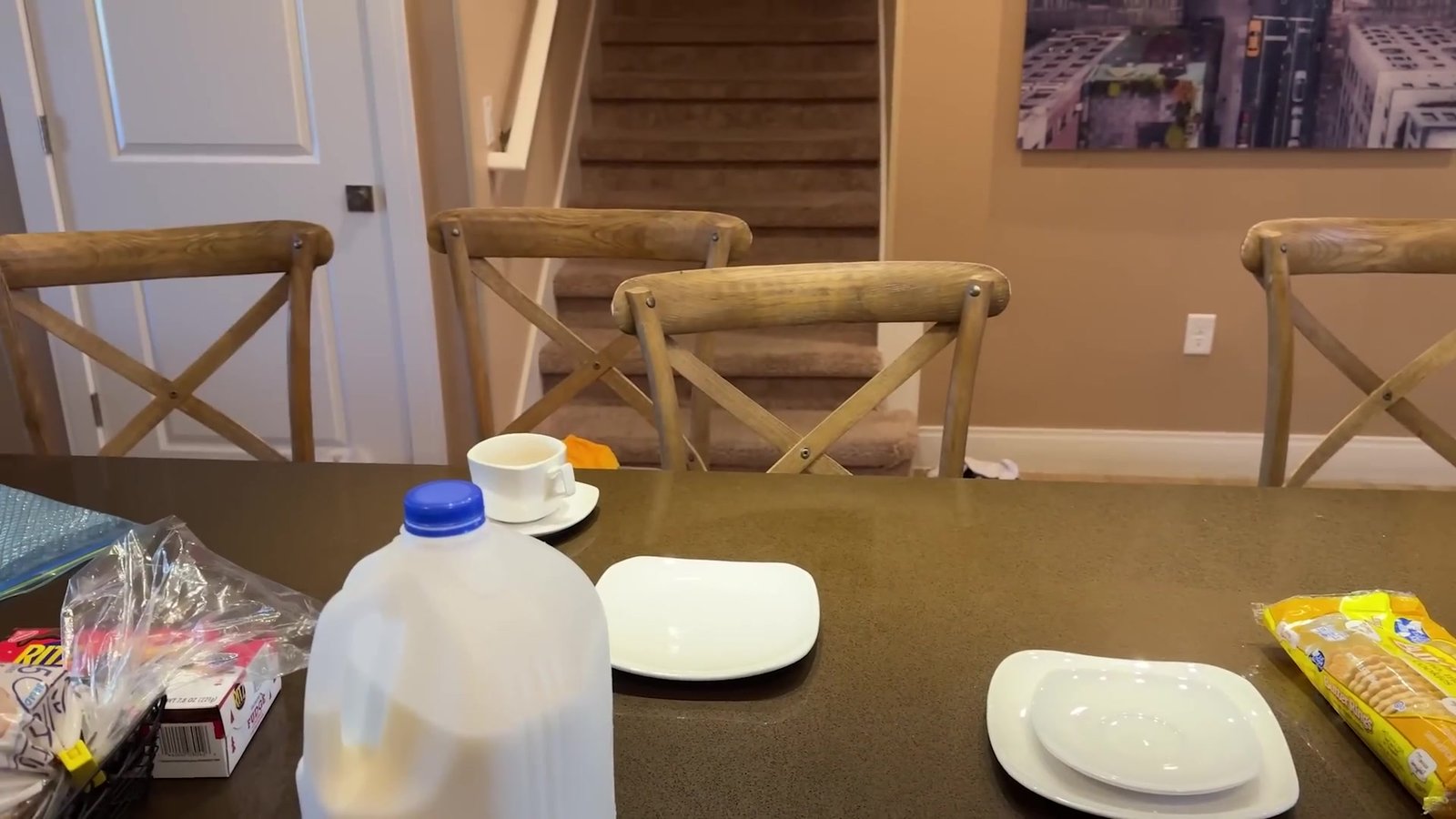 Mesa de jantar da casa com leite, cereal e pratos do café da manhã