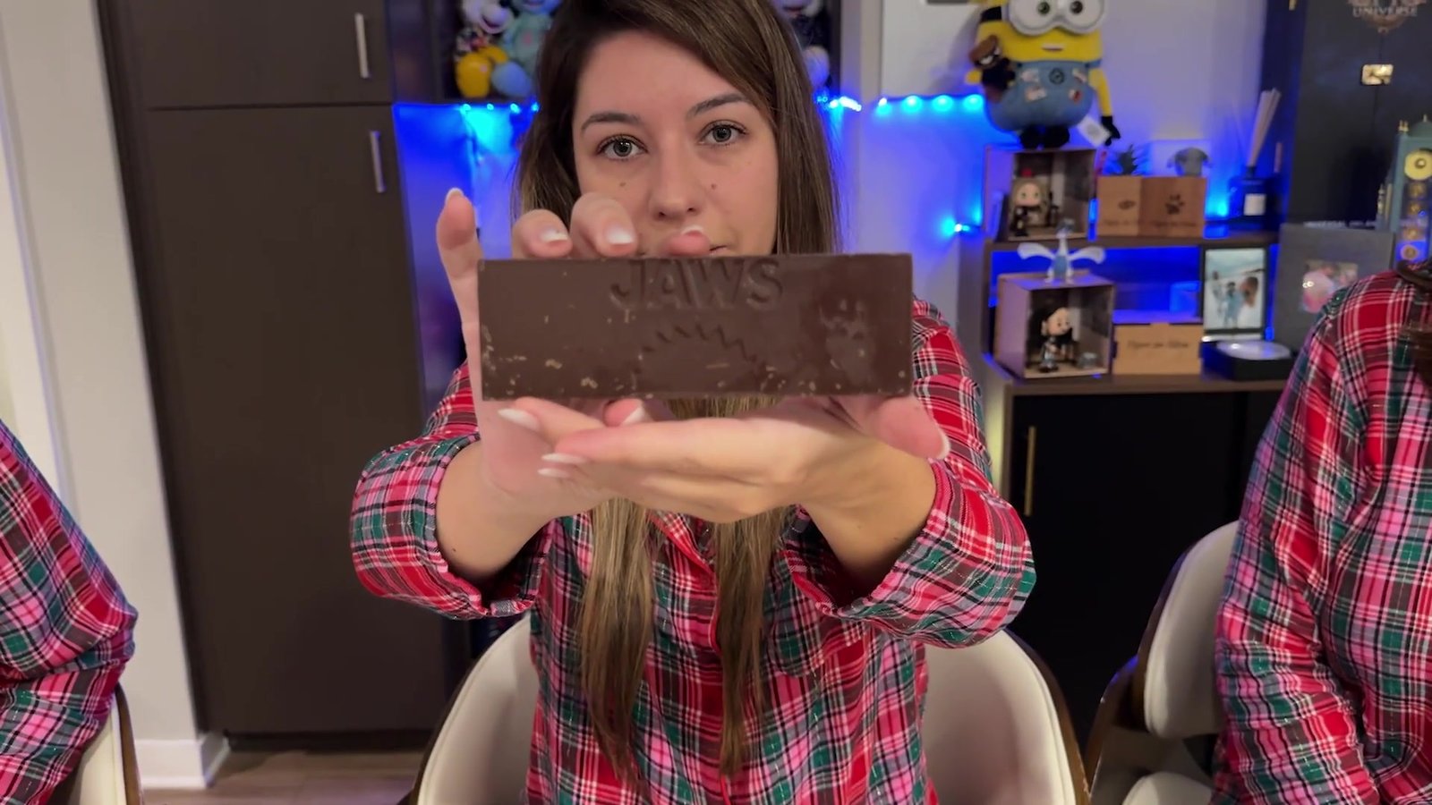 Gabi segurando a barra de chocolate do Tubarão (Jaws) aberta, com o nome em relevo