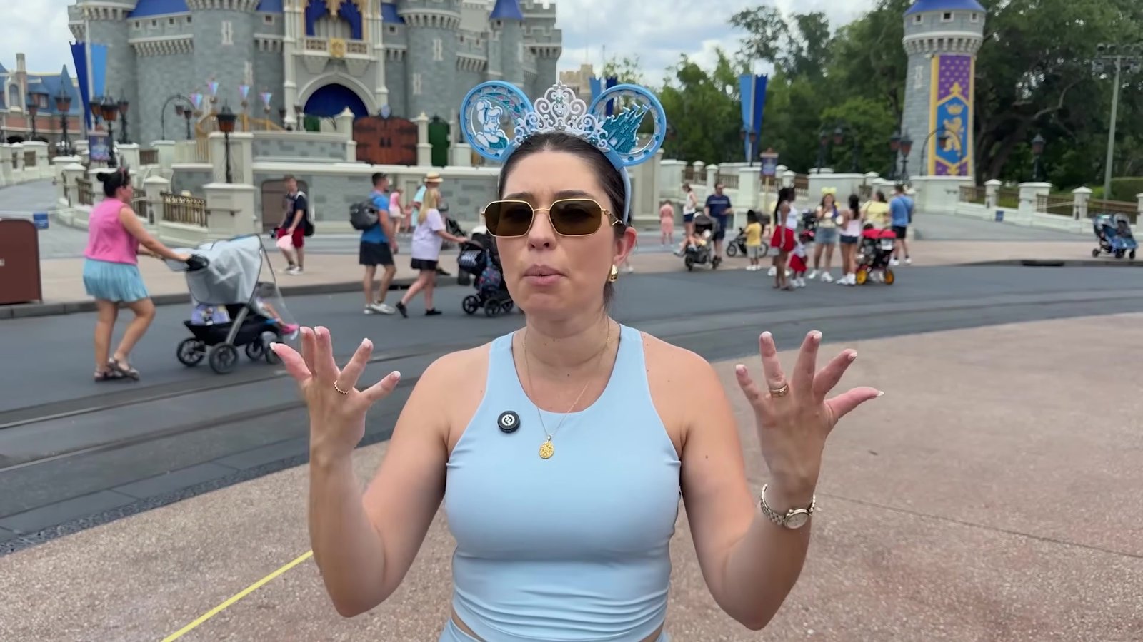 Gabi do Turistorlando de tiara da Minnie em frente ao Castelo da Cinderela explicando o teste de snacks