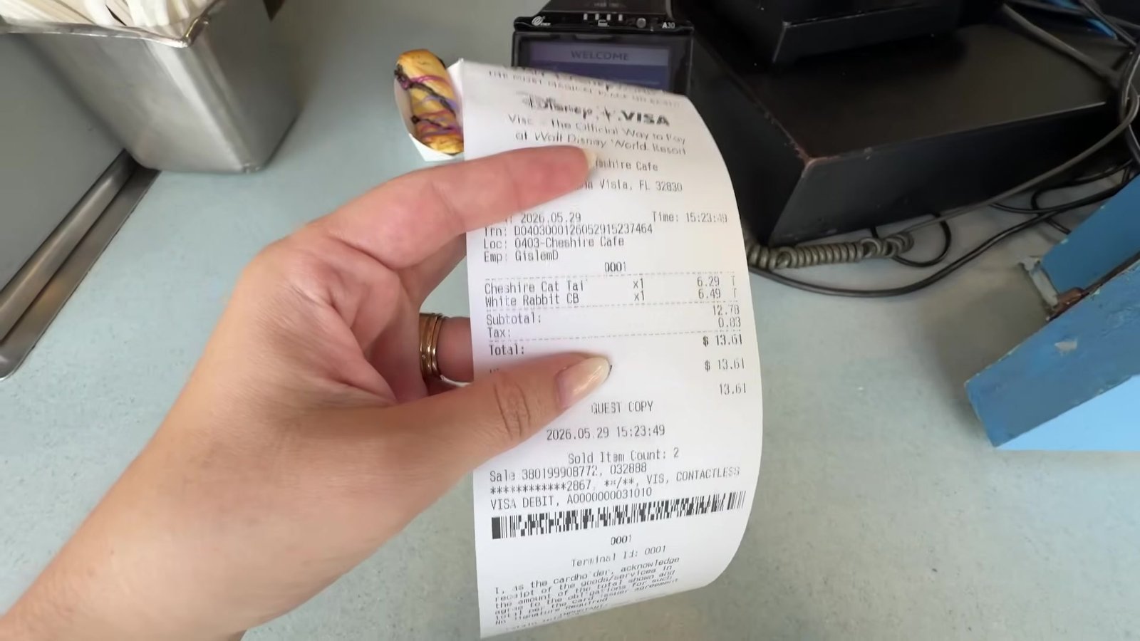 Recibo do Cheshire Café mostrando o Cheshire Cat Tail e o White Rabbit Cold Brew pagos no cartão