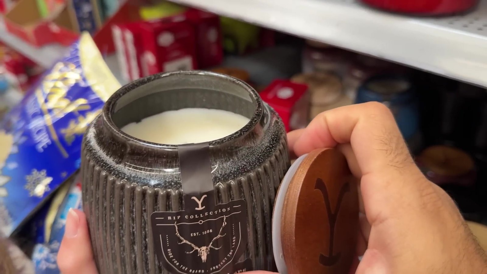 Vela natalina de marca em pote de vidro na mão, achado da promoção pós-Natal do Walmart