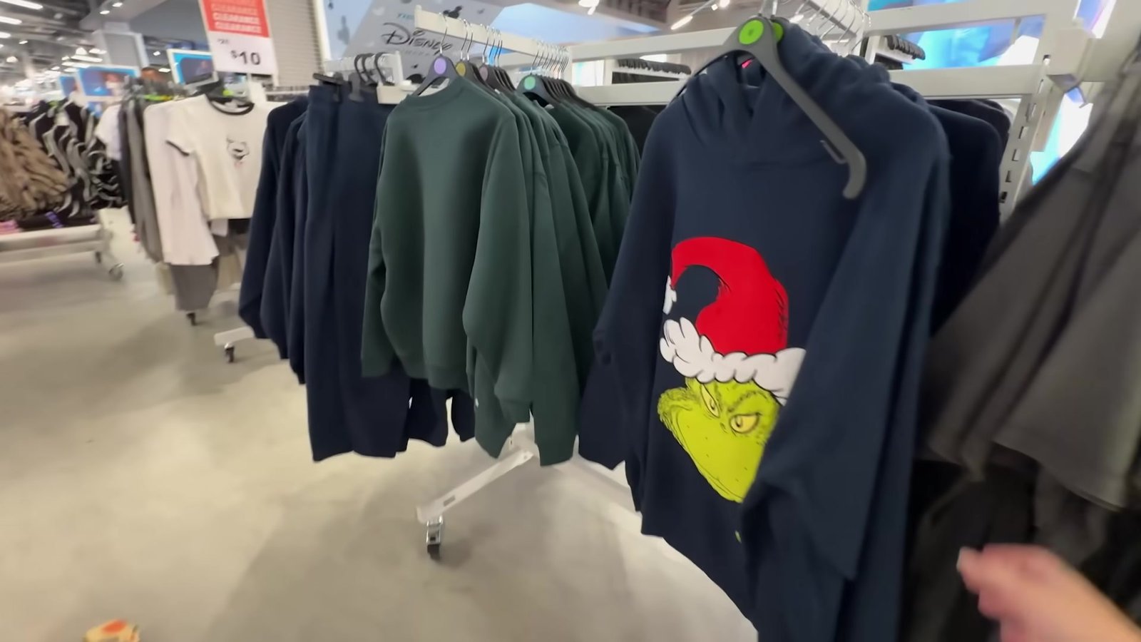 Moletons do Grinch pendurados na arara da coleção de Natal da Primark do Florida Mall