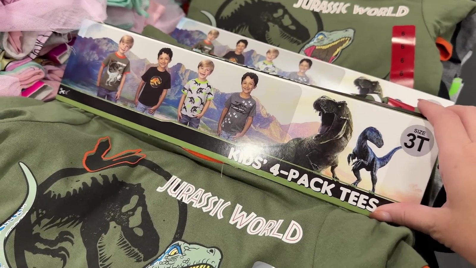 Kit de 4 camisetas infantis do Jurassic World na seção de roupas do Costco