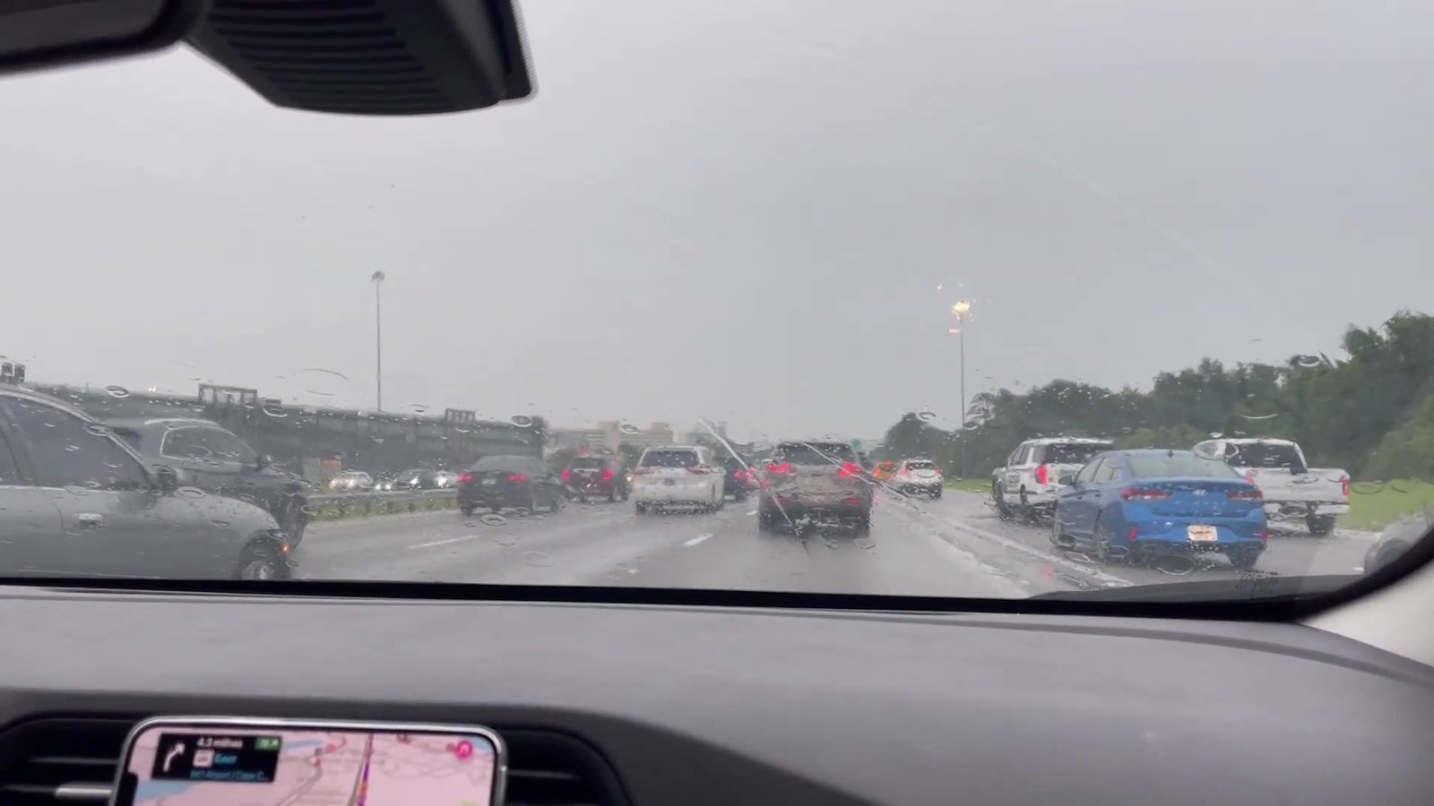 Rodovia molhada de chuva com vários carros a caminho do aeroporto de Orlando
