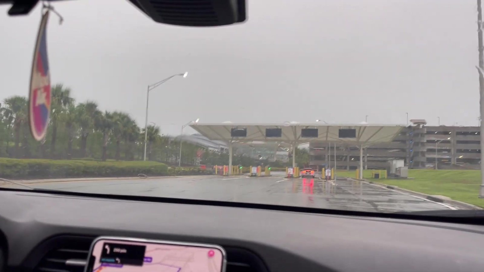 Chegada à cancela do estacionamento do Terminal C do aeroporto de Orlando em dia de chuva