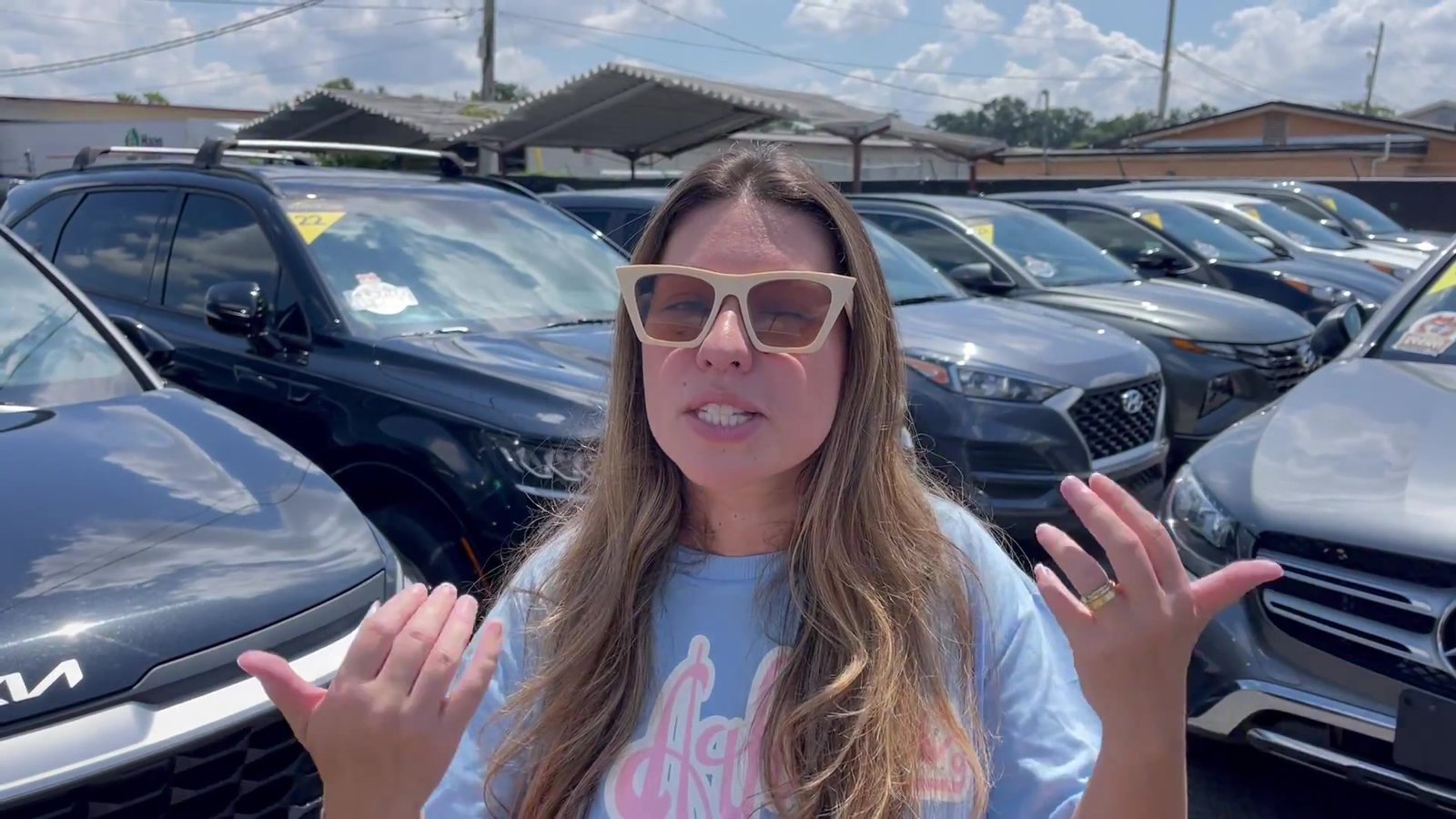 Gabi no pátio de uma locadora de carros em Orlando, entre os carros disponíveis para aluguel