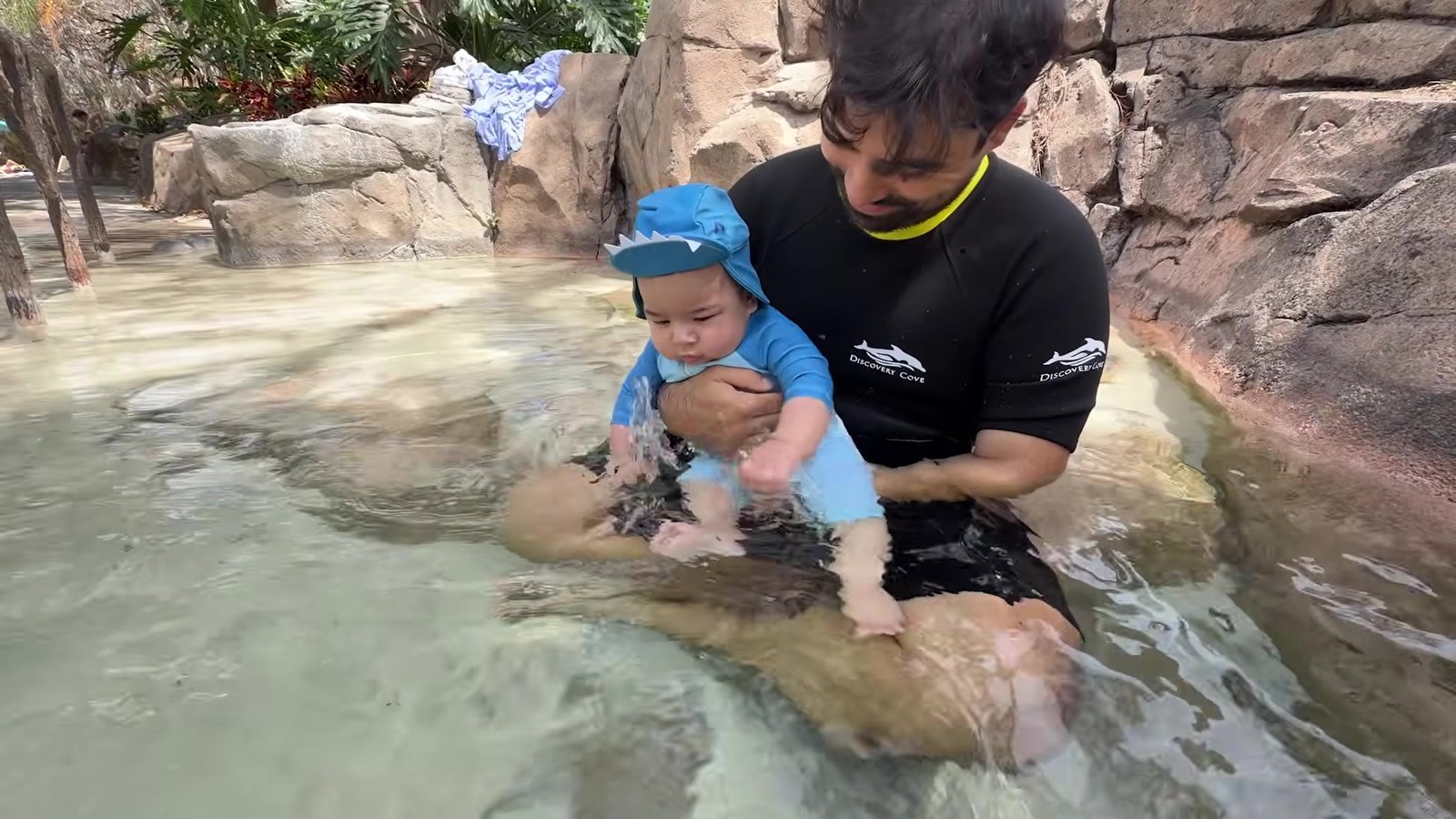 Gustavo segurando o Lian, de 5 meses, na piscina rasa de água doce do Discovery Cove