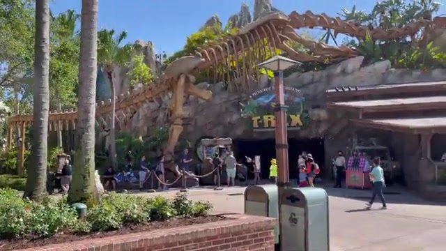 Fachada do T-Rex Café no Disney Springs, com esqueleto de dinossauro gigante sobre a entrada