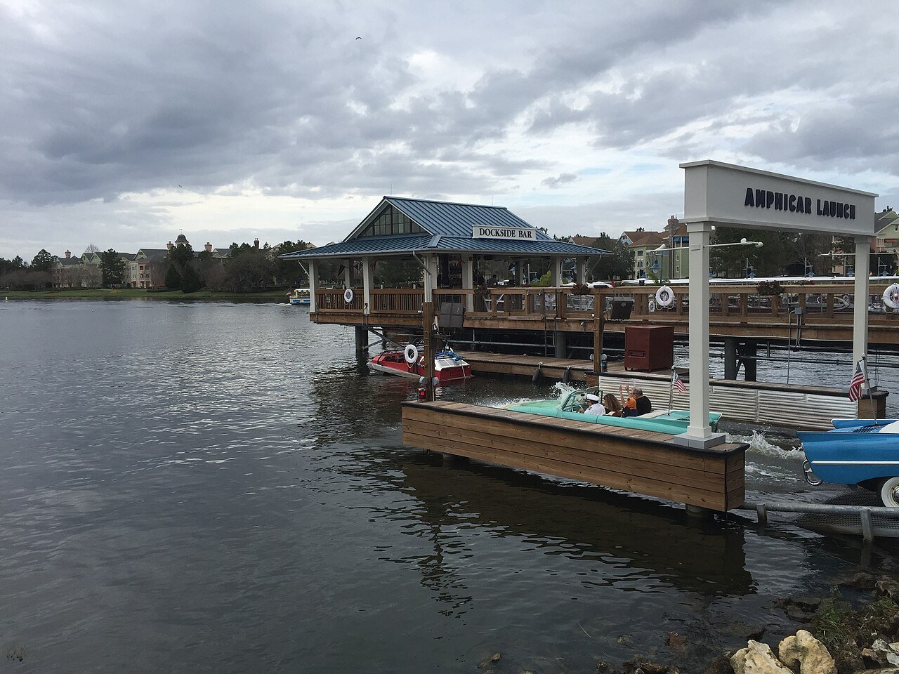 Píer do The BOATHOUSE no Disney Springs, com os carros anfíbios Amphicar entrando no lago