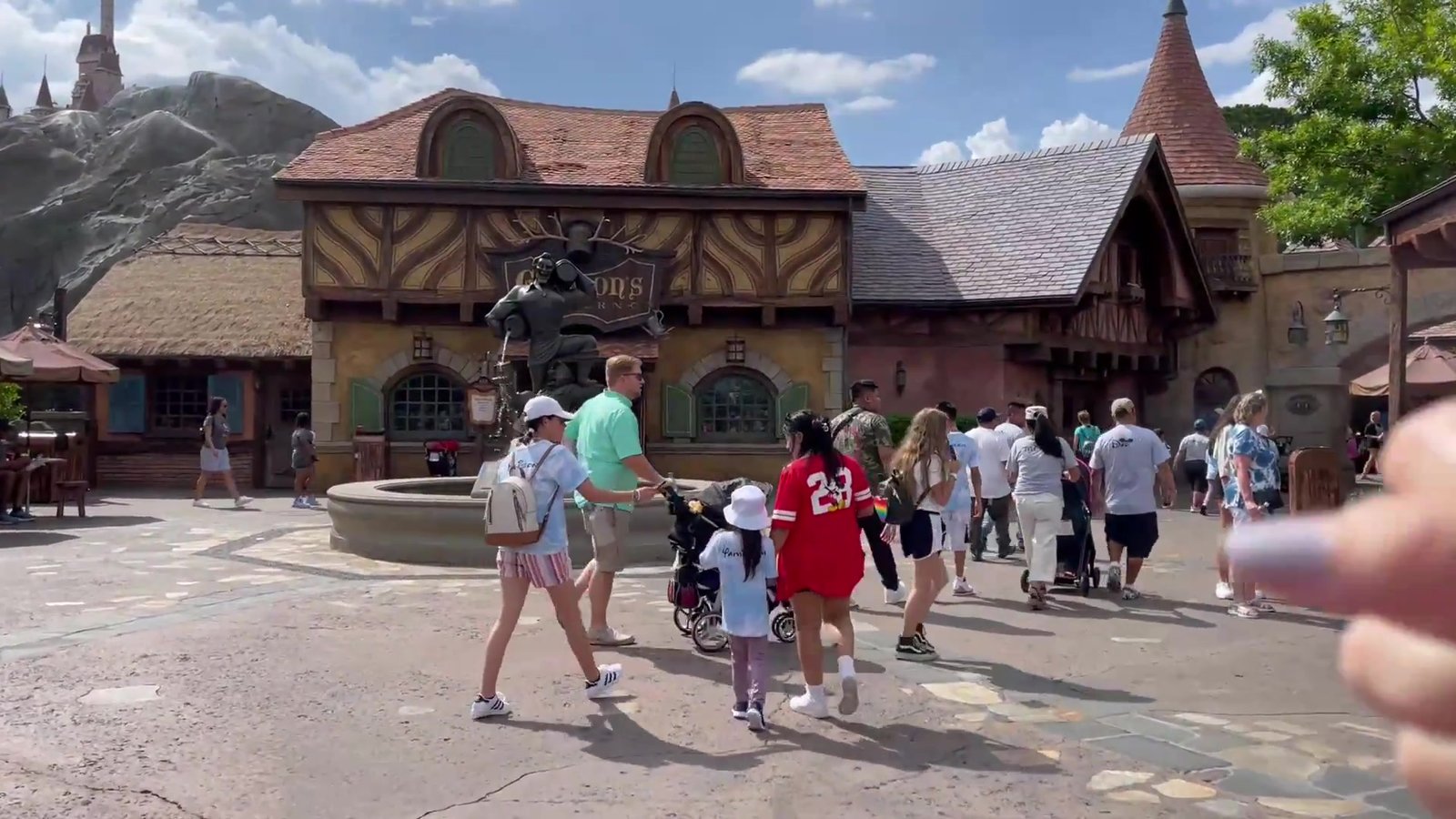 Vila da Bela e a Fera na Fantasyland, com a fonte e a estátua do Gaston
