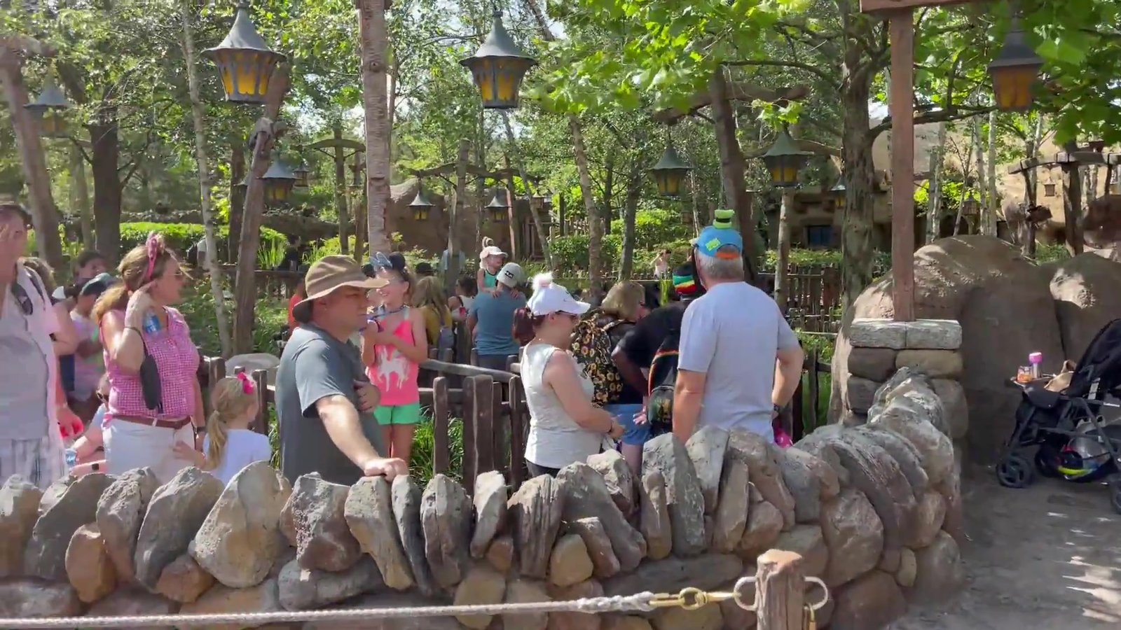 Fila da Seven Dwarfs Mine Train serpenteando entre muros de pedra na Fantasyland