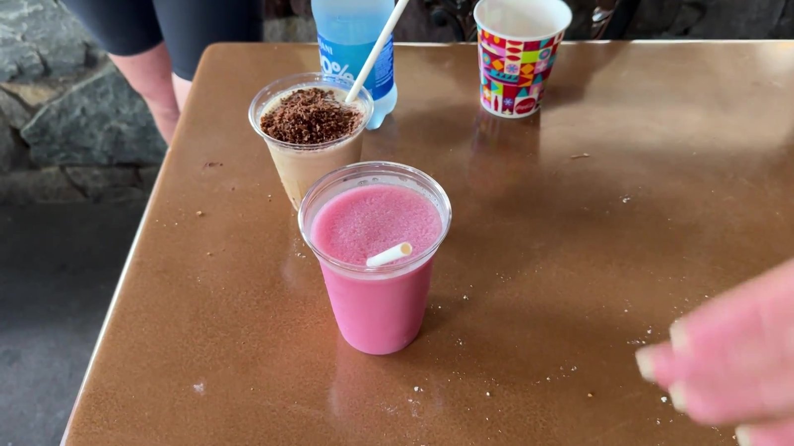 Dois drinks frozen na mesa, um rosa de blackberry e um marrom de café, durante o Drinking Around the World