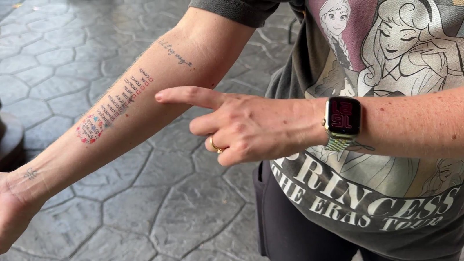 Braço com a tatuagem temporária dos países já marcados com check no fim do Drinking Around the World
