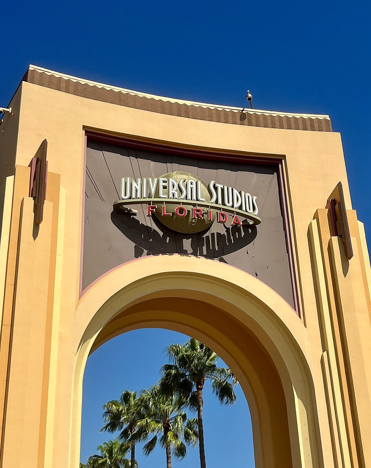 Arco de entrada do Universal Studios Florida com o globo da Universal e palmeiras ao fundo