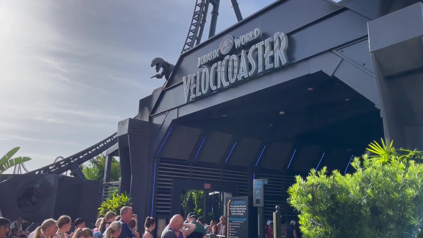 Entrada da VelociCoaster no Islands of Adventure com visitantes chegando