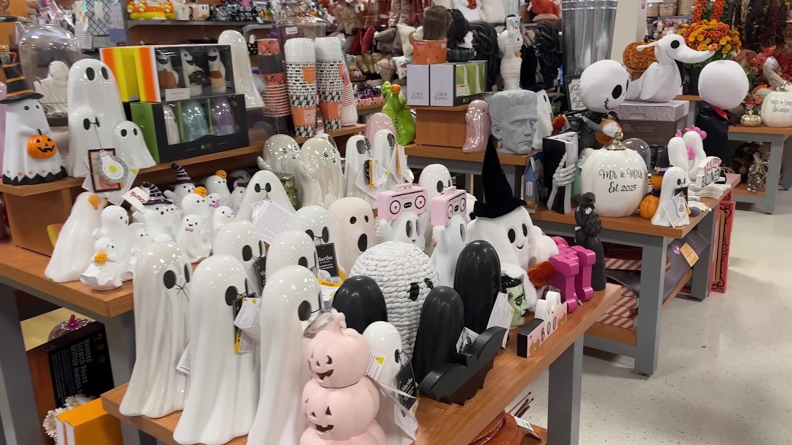 Mesa de decoração de Halloween com fantasminhas e abóboras numa loja de departamento