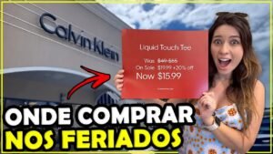 Gabi na frente da Calvin Klein do outlet segurando a placa de promoção de feriado: camiseta de US$ 49 por US$ 15,99
