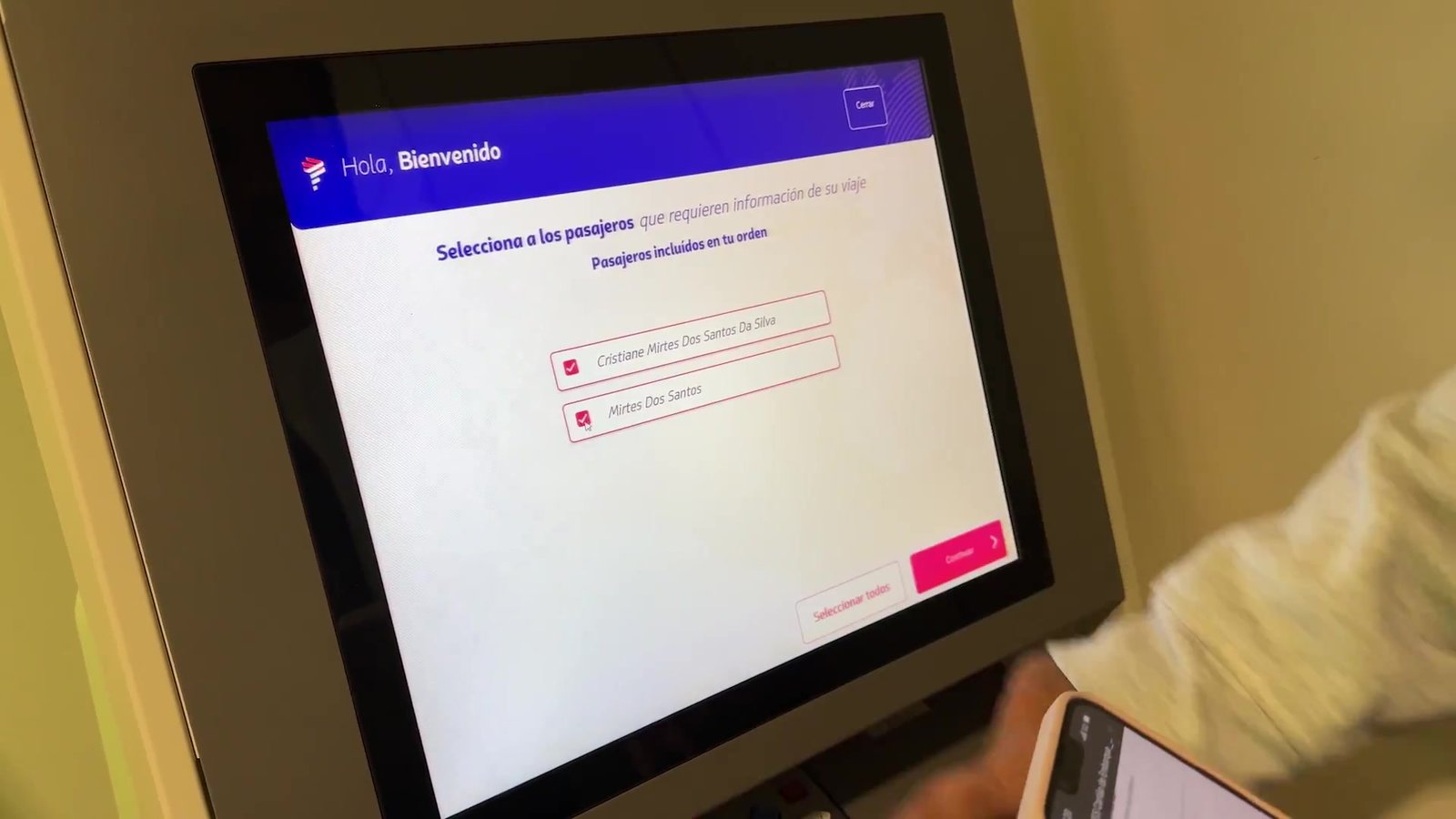 Tela do totem de check-in pedindo para selecionar os passageiros da reserva