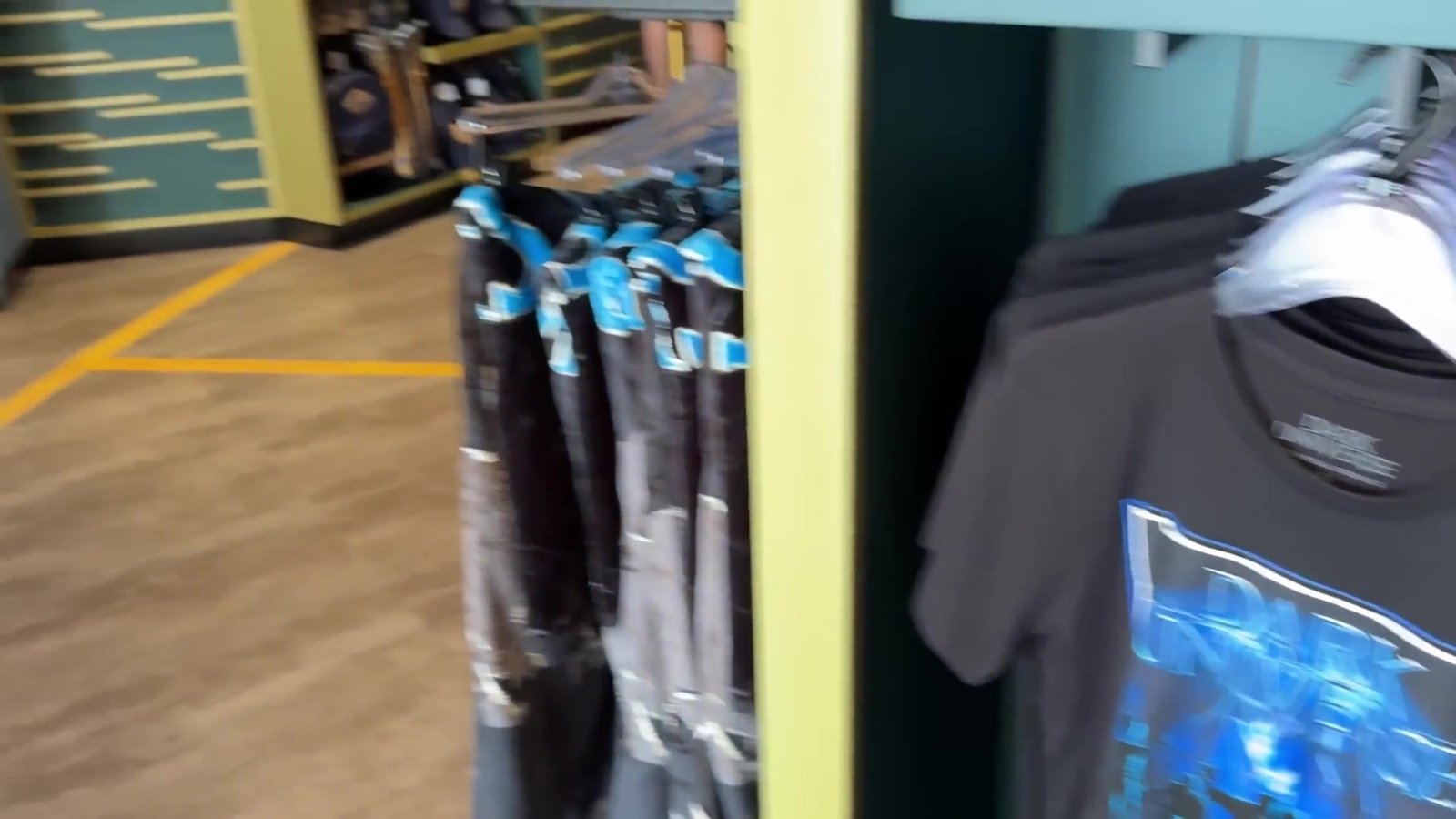 Camisetas do Epic Universe penduradas na loja do Celestial Park