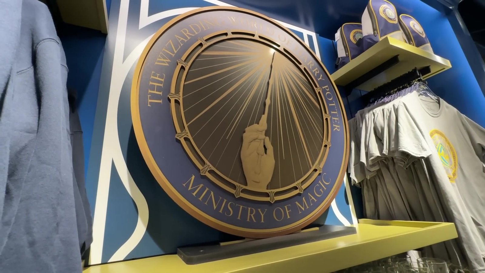 Loja do Ministério da Magia no Epic Universe com o brasão do Ministério e camisetas