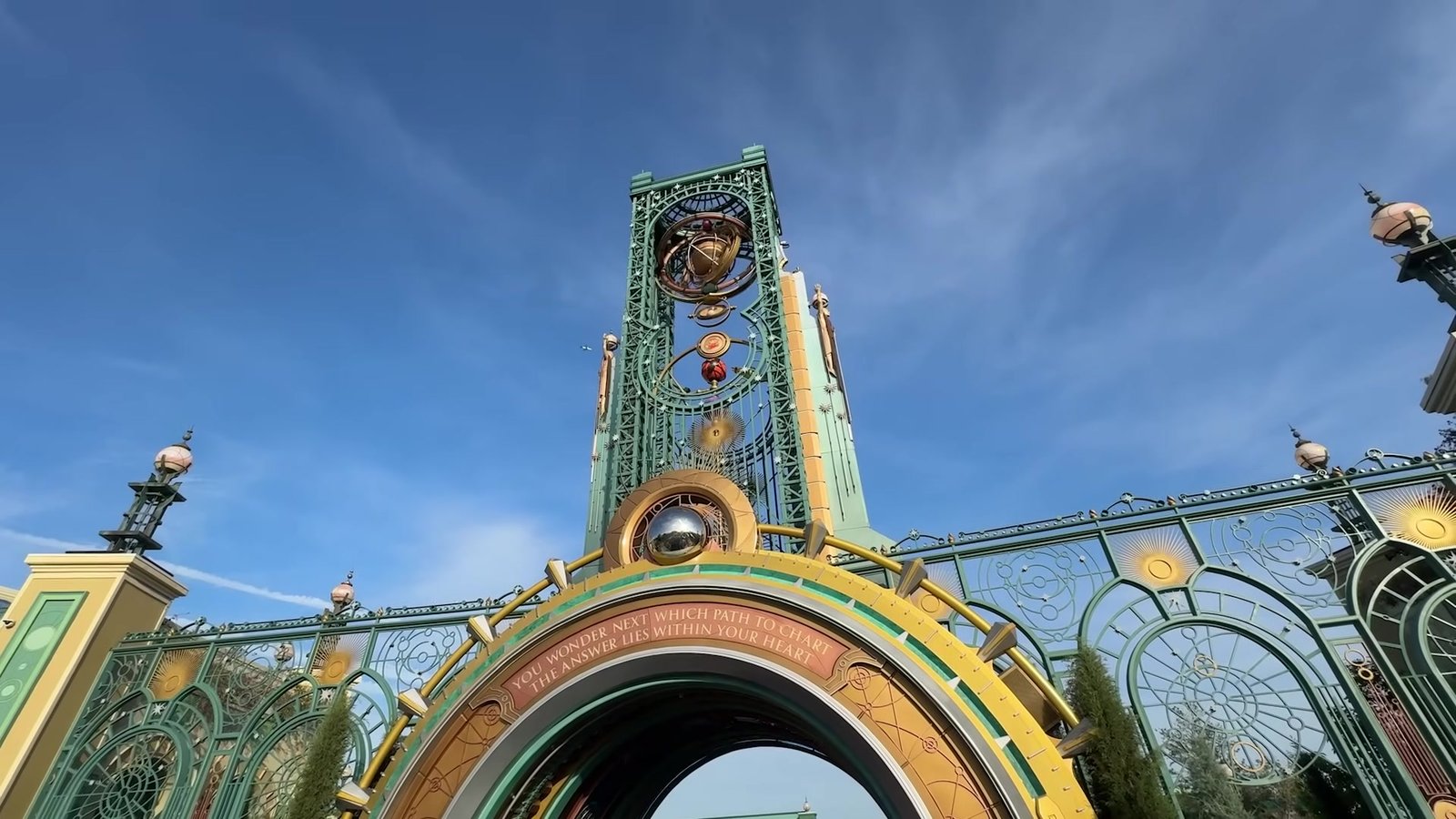 Portal de entrada do Epic Universe com a Chronos Tower vista de baixo, em dia de céu azul