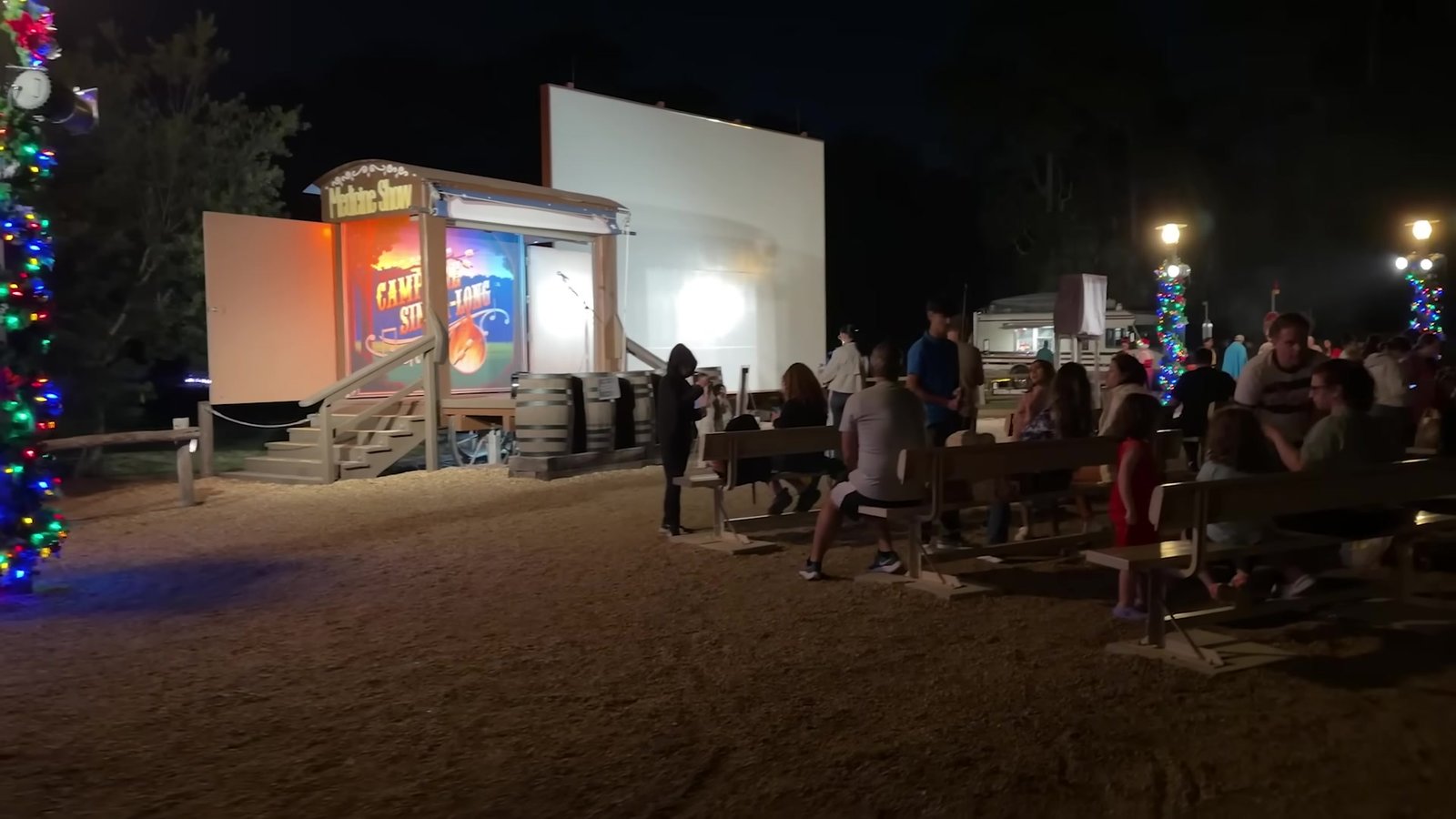 Telão e arquibancada de madeira do Campfire Sing-Along no Fort Wilderness à noite