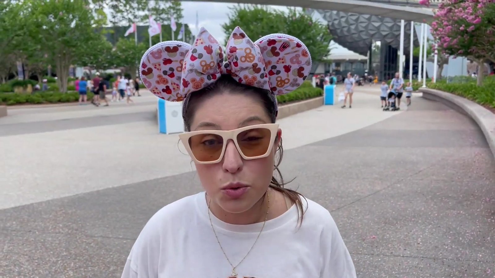 Gabi de orelhinhas da Minnie explicando as dicas de foto na entrada do EPCOT