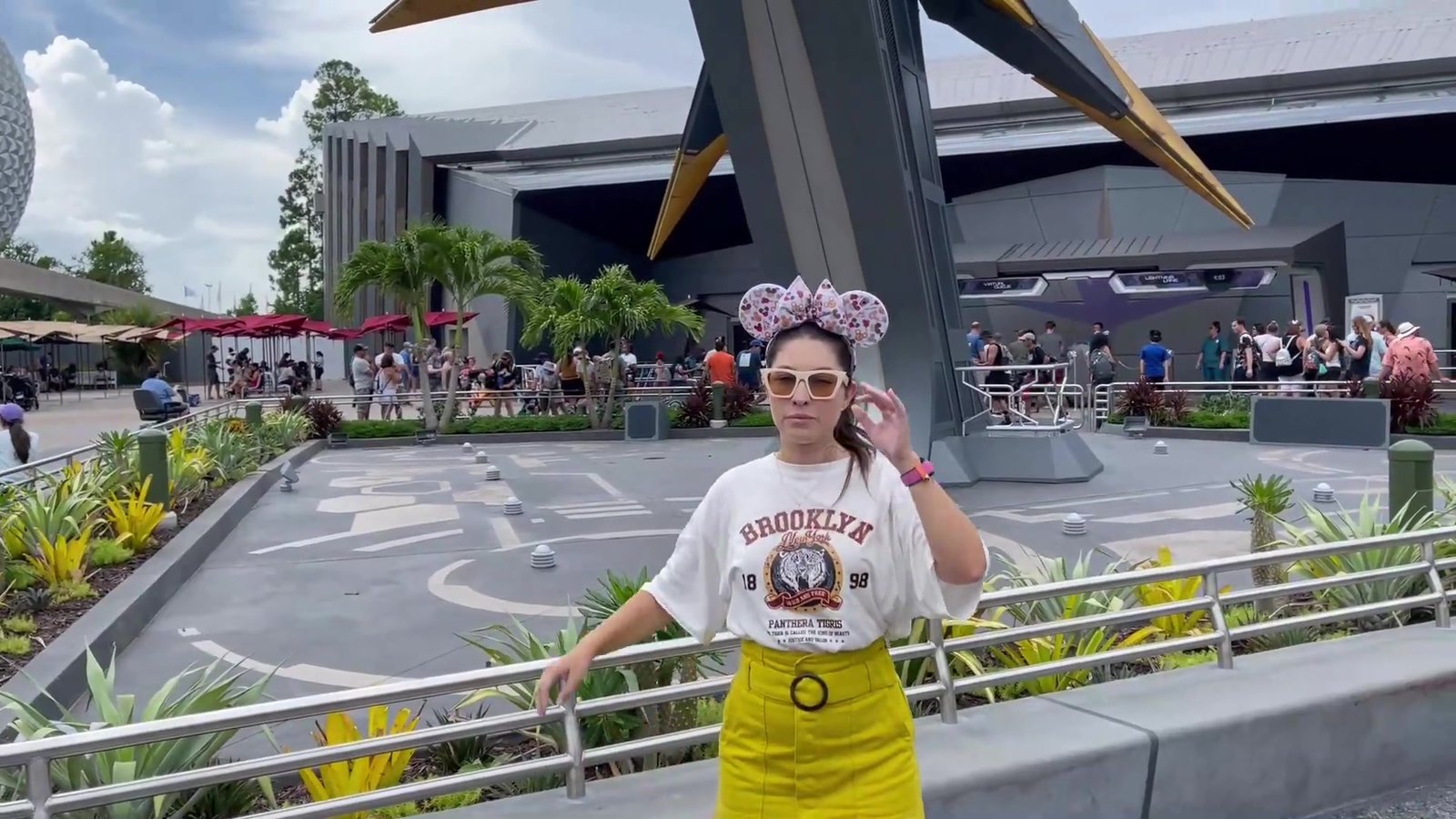 Gabi em frente ao prédio da Guardians of the Galaxy: Cosmic Rewind, com a nave dourada ao fundo