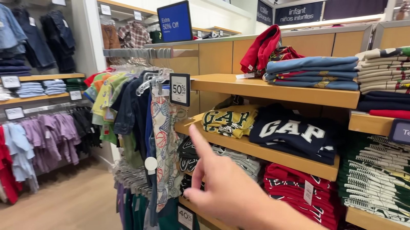Seção GAP Kids do outlet com camisetas com logo e placa de 50% de desconto