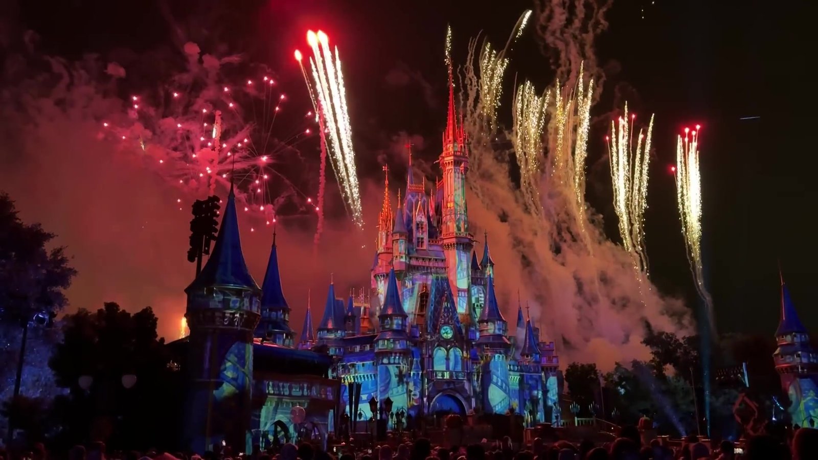 Fogos vermelhos e dourados explodindo sobre o castelo do Magic Kingdom na festa de Halloween