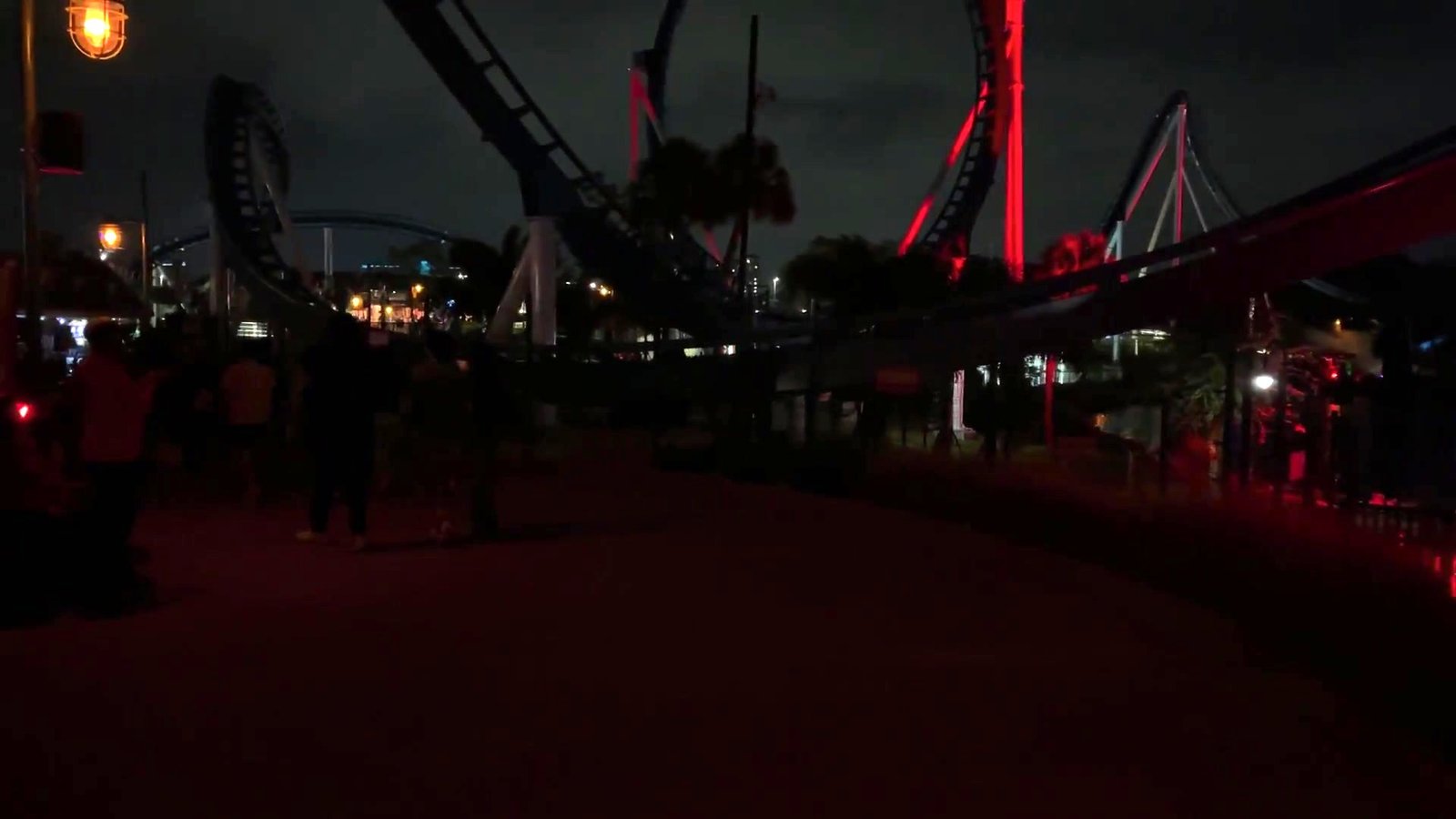Montanha-russa do SeaWorld iluminada em vermelho à noite durante o Howl-O-Scream