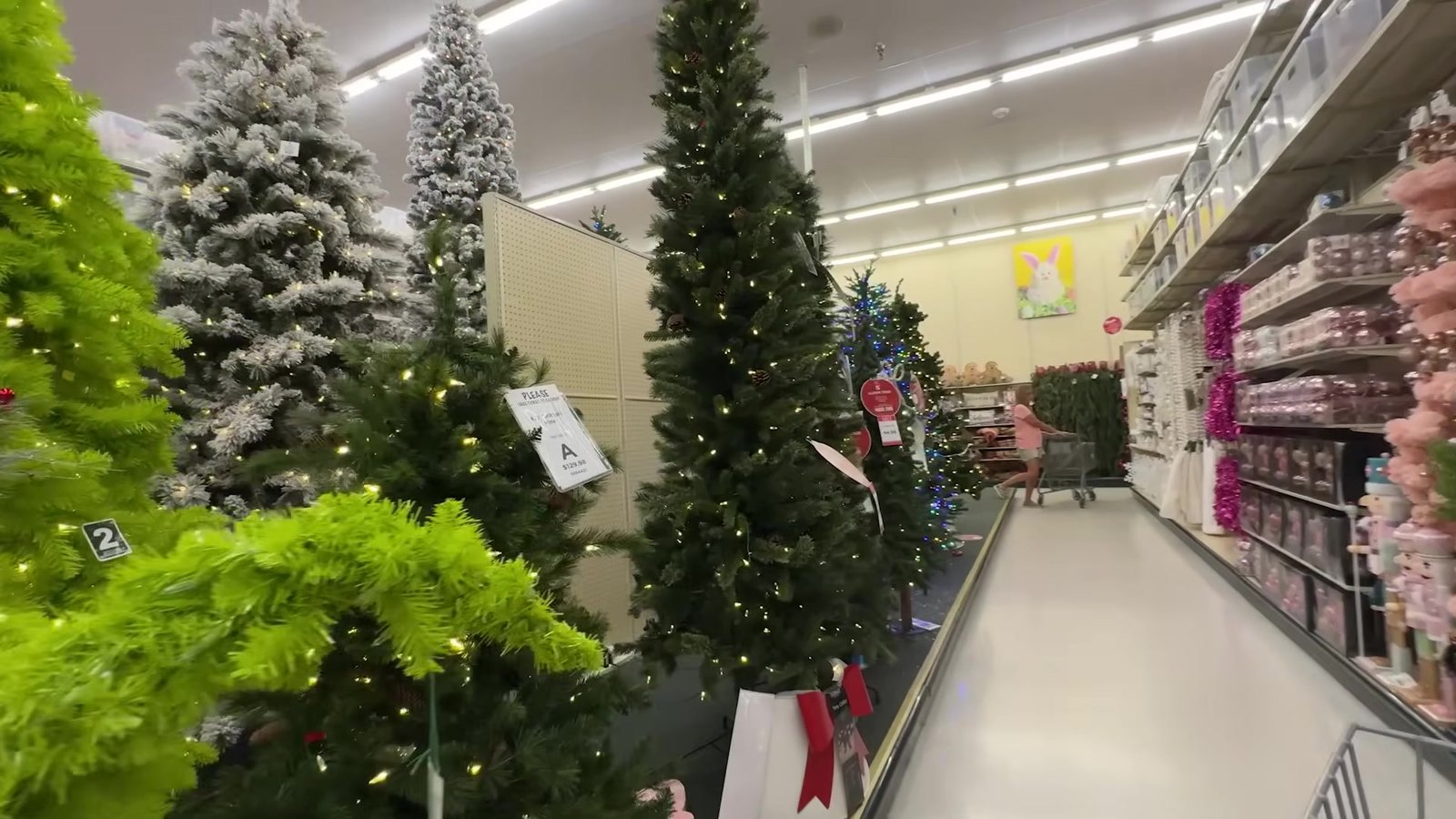 Corredor de árvores de Natal artificiais montadas na Hobby Lobby, verdes e nevadas