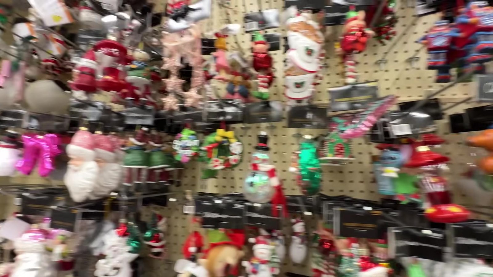 Parede de ornamentos de árvore de Natal pendurados na Hobby Lobby, com bonecos de gengibre e bichinhos