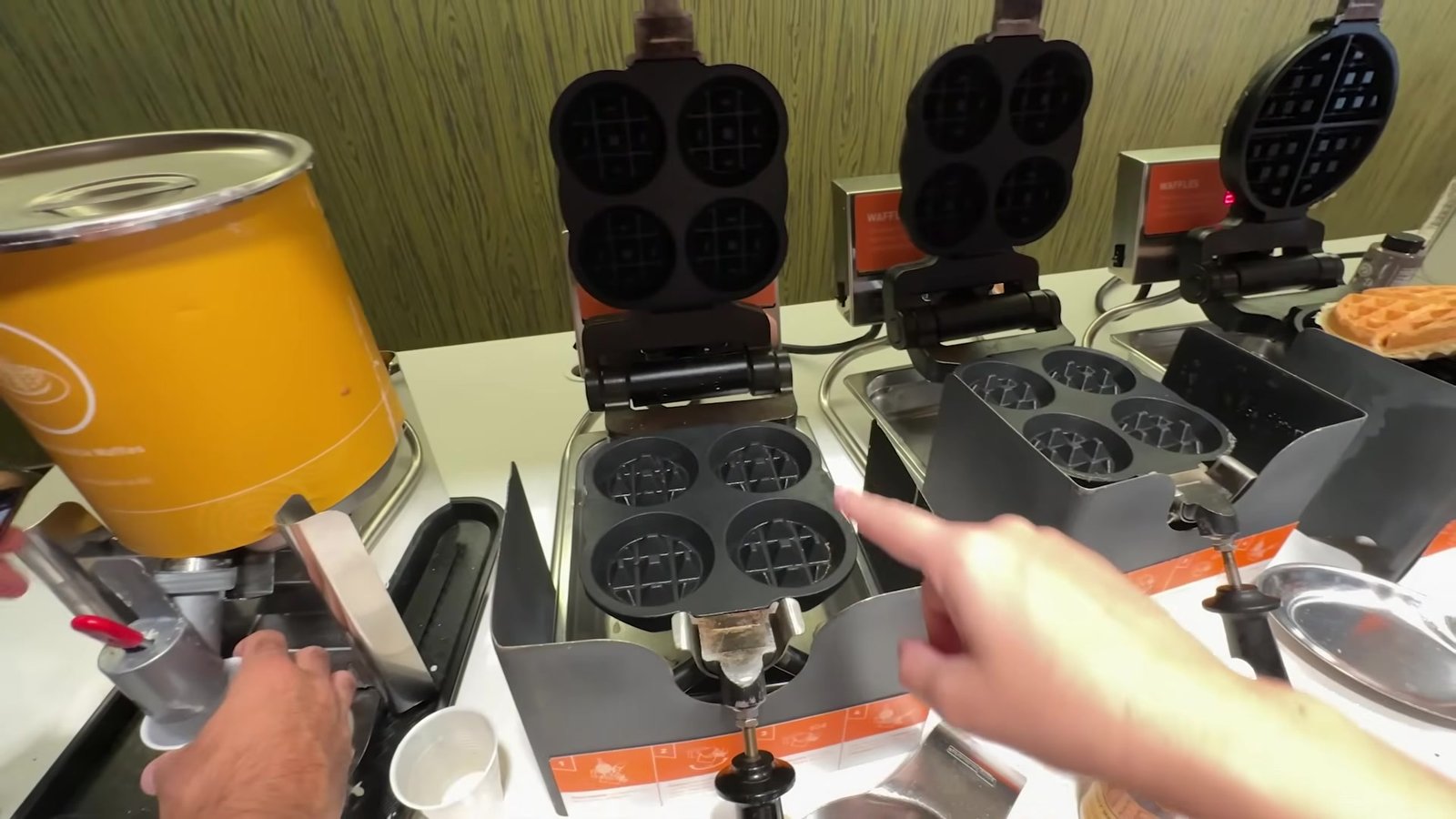 Máquinas de waffle enfileiradas e dispenser de massa na área do café da manhã do Home2 Suites
