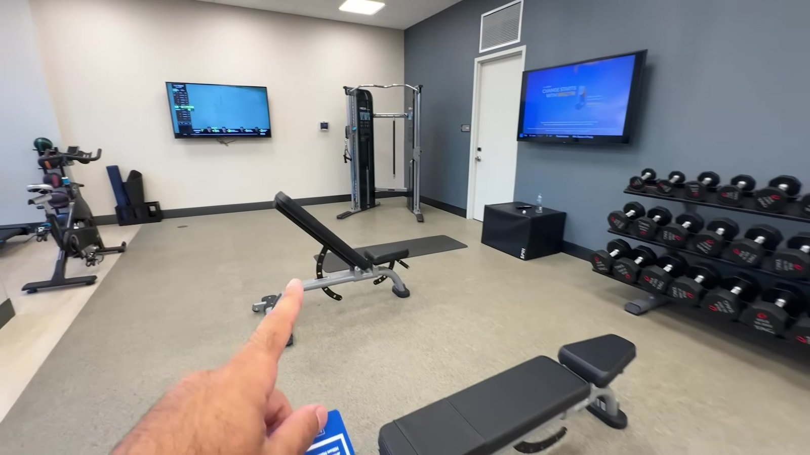 Academia 24 horas do Homewood Suites com halteres, banco e máquina de crossover