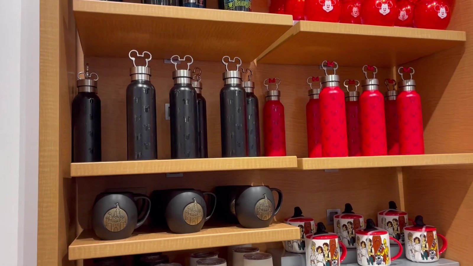 Garrafas térmicas e canecas do Mickey e das princesas na prateleira