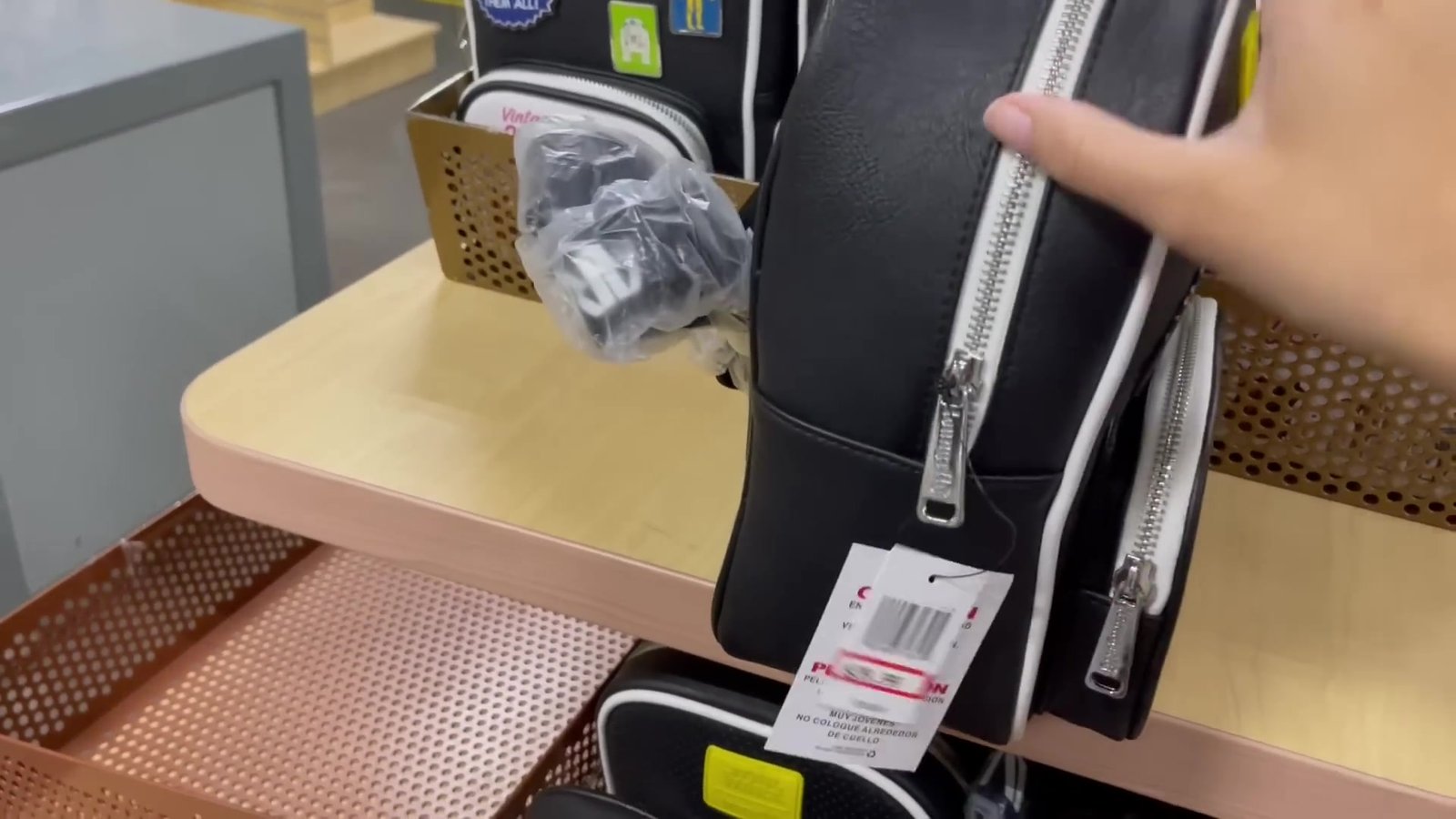 Mochila Loungefly preta com etiqueta de preço na loja secreta da Disney