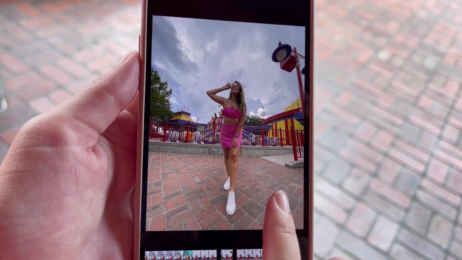 Celular mostrando a foto da Gabi posando na área colorida da Storybook Circus no Magic Kingdom