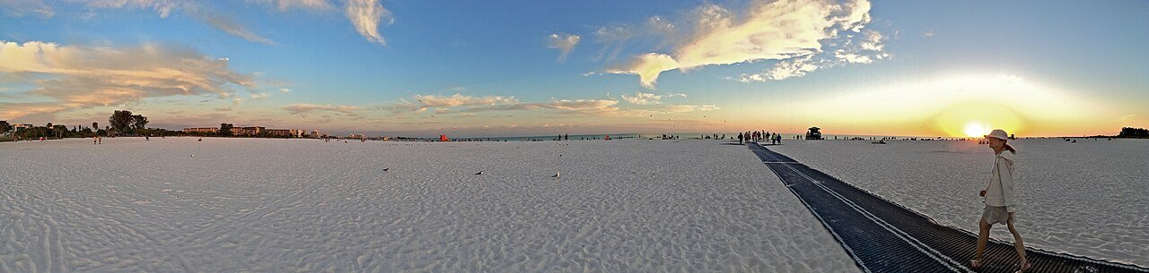 Pôr do sol na Siesta Beach com a areia branca e o tapete de acesso à praia