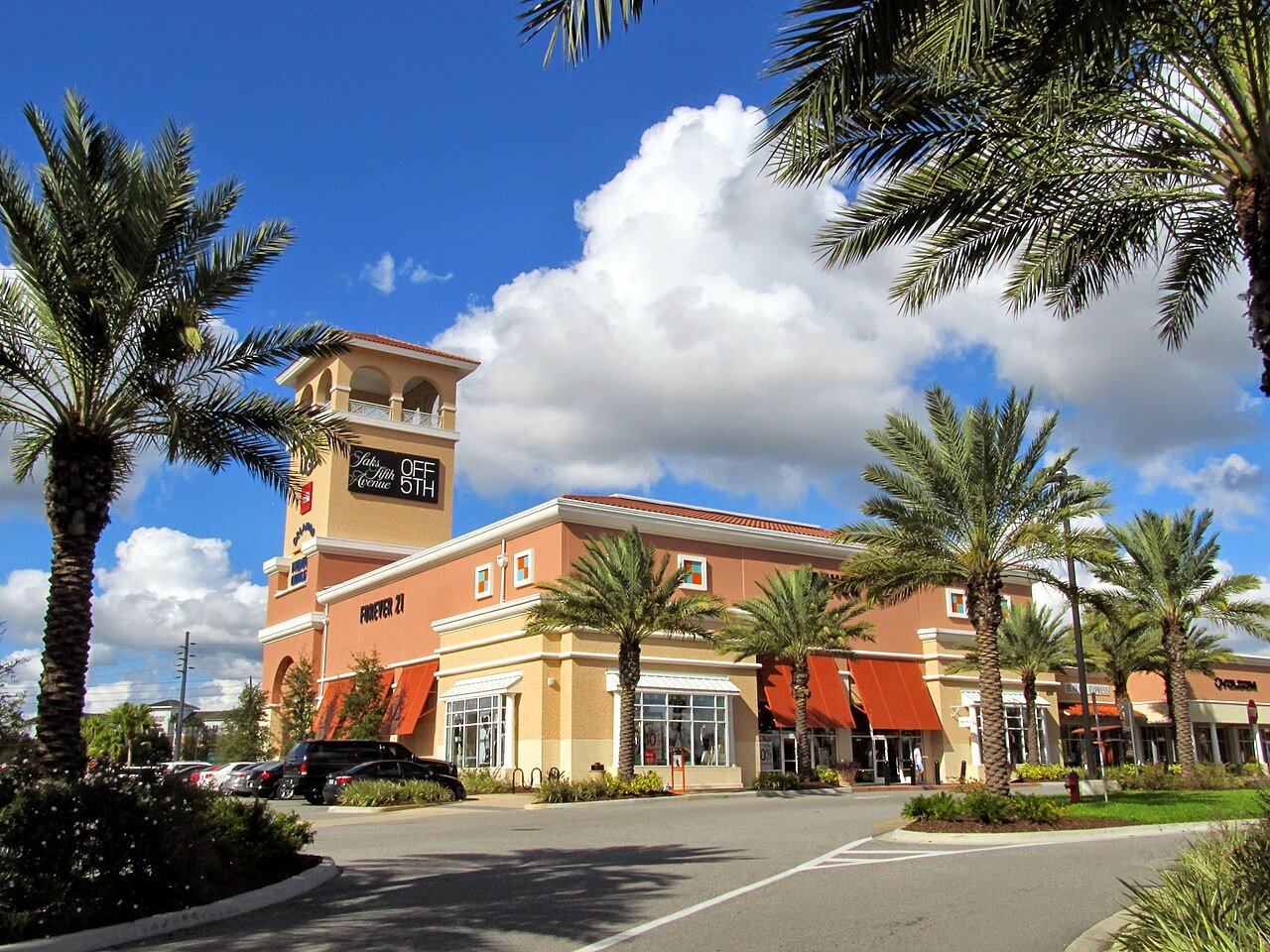 Fachada do Orlando Premium Outlets com palmeiras e a torre da entrada