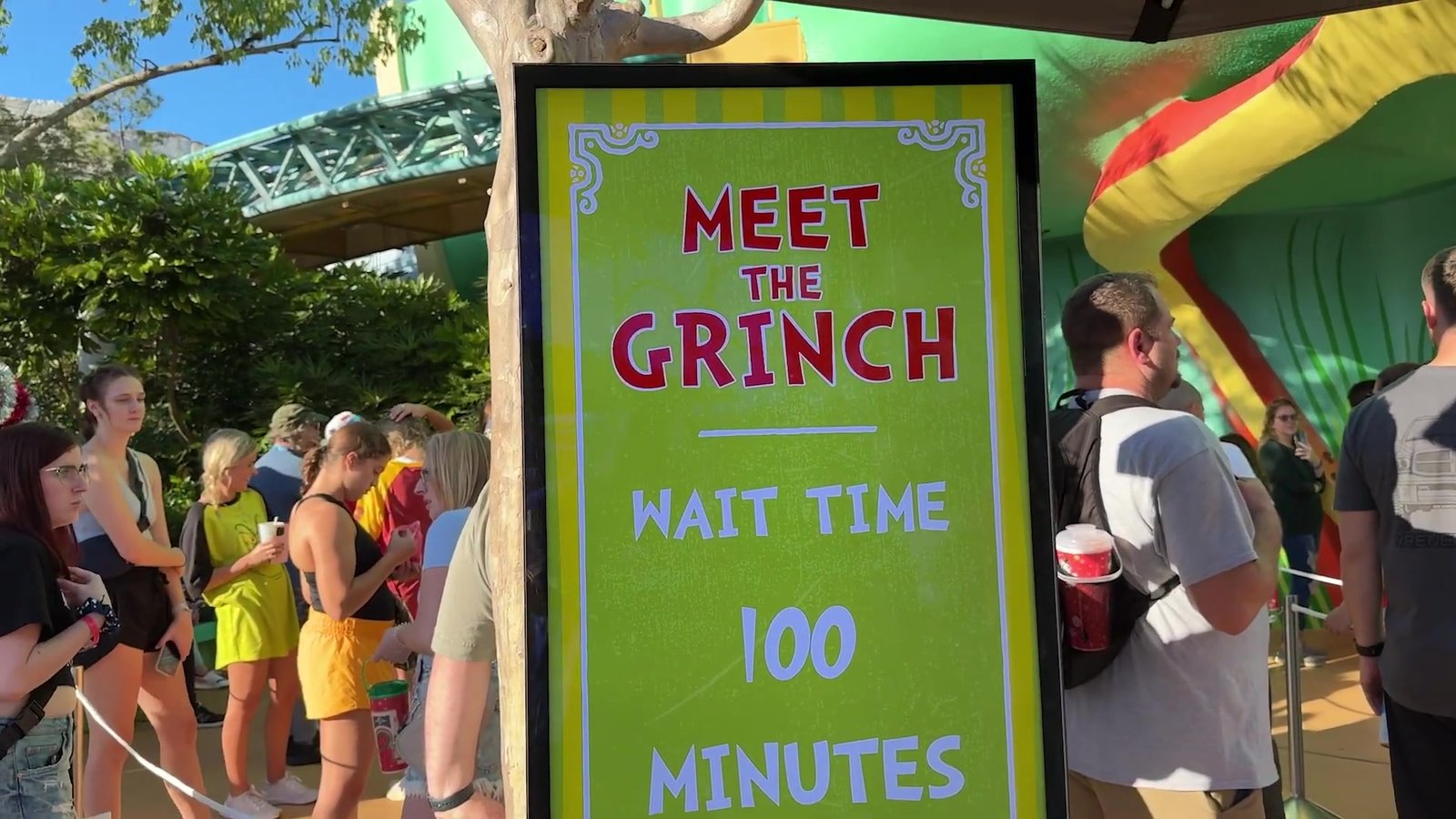 Placa Meet the Grinch marcando 100 minutos de espera, com a fila ao lado, na Seuss Landing